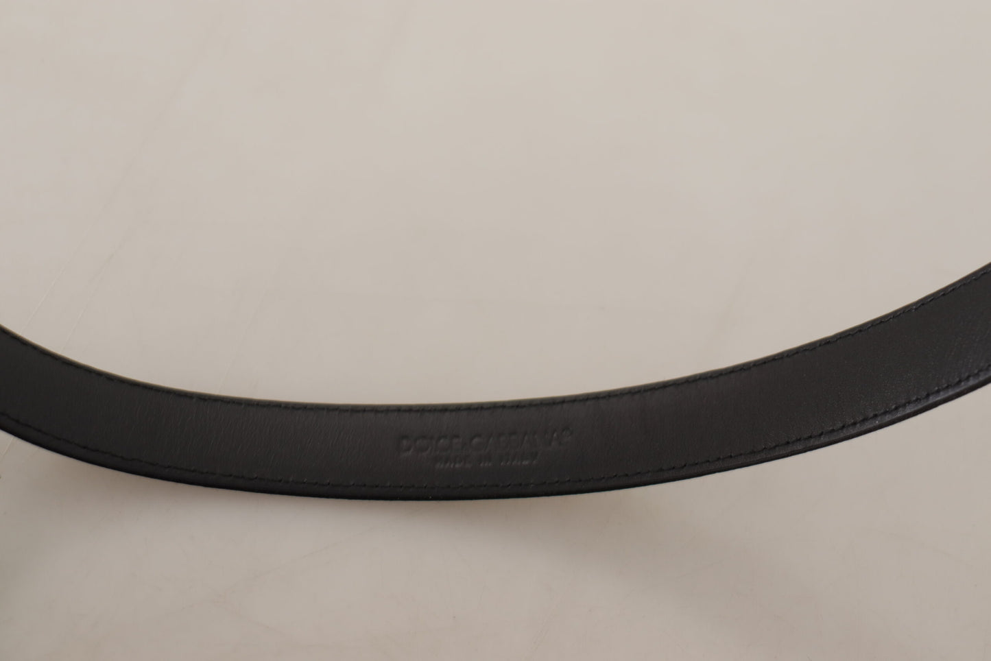 Ceinture en cuir de veau noir avec boucle en métal argenté et logo de la marque Dolce & Gabbana.