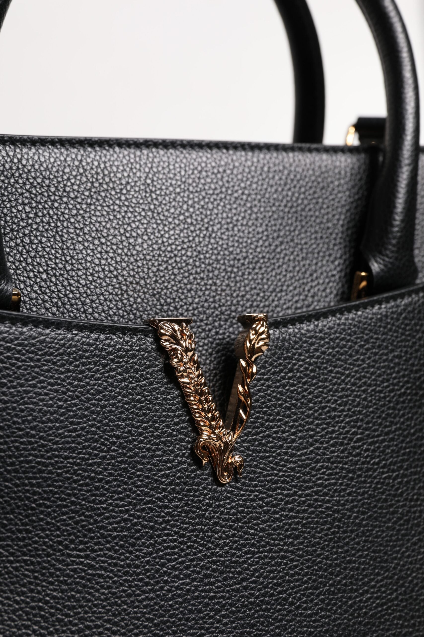 Grand sac à main porté épaule et porté bandoulière en cuir noir avec poignée supérieure.